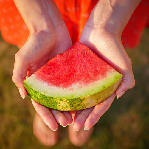 Frau hält eine Melone